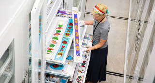 Dr. Anne Lawlor looks at a beaded belt in the museum's collections.