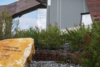 A rock inscribed with poetry outside a museum. 