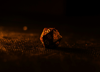 lone D20 die lit in warm light from the left side in amber tones
